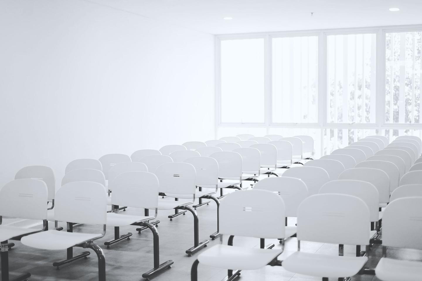 Heller Besprechungsraum mit weißen Stühlen